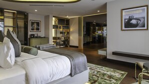 A modern hotel room with a large bed, a desk, and a seating area. - The Delborough Lagos (Lagos)