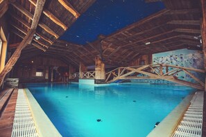 Una piscina techada, sillones reclinables de piscina