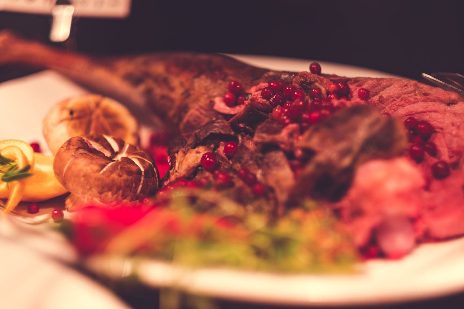 A roasted turkey with cranberries and a side of vegetables on a plate.