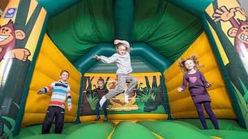 Kids can play and jump on the jungle-themed inflatable structure with a slide.