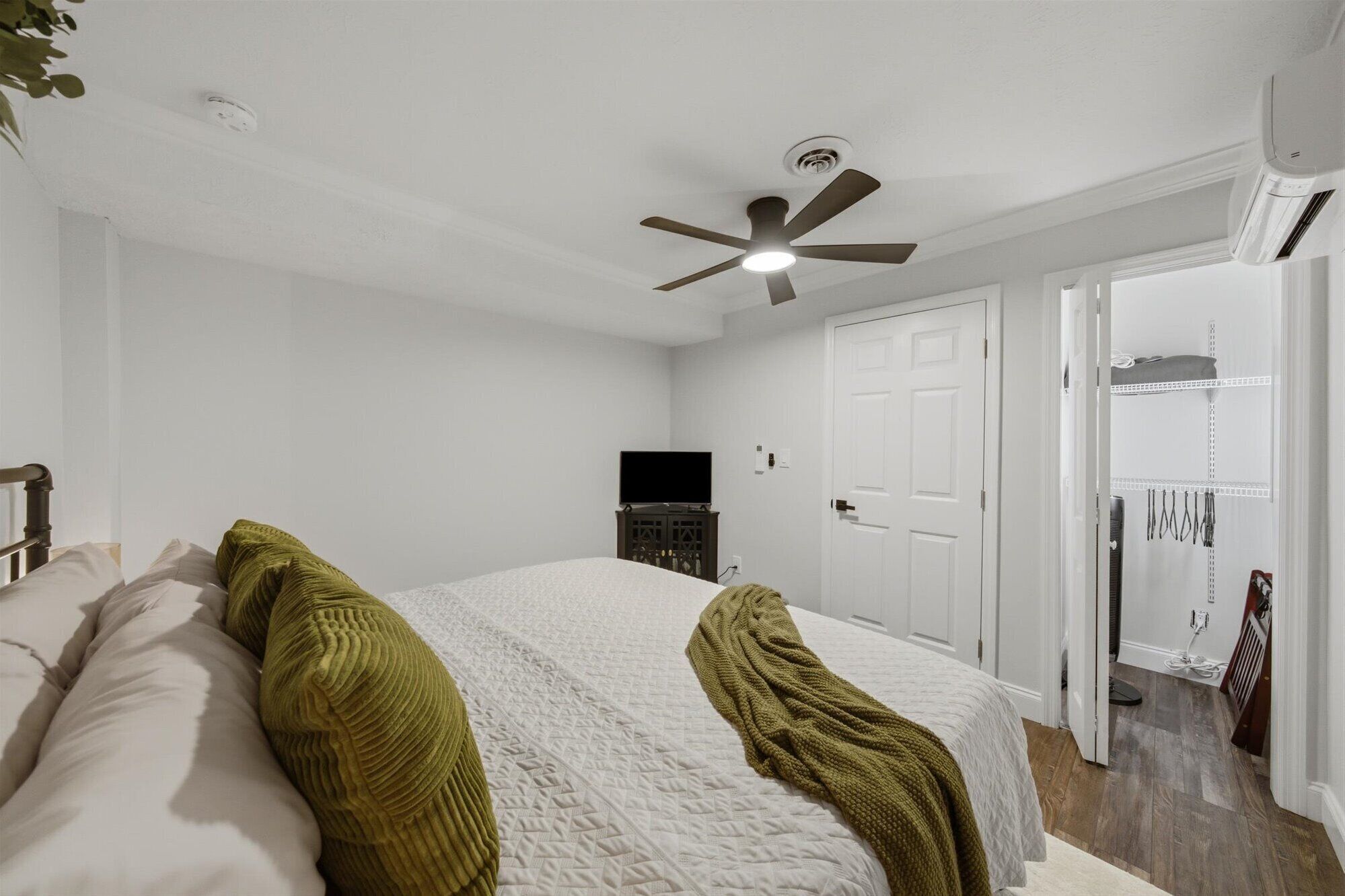 Bright, cozy bedroom with king bed, AC, ceiling fan, and spacious closet