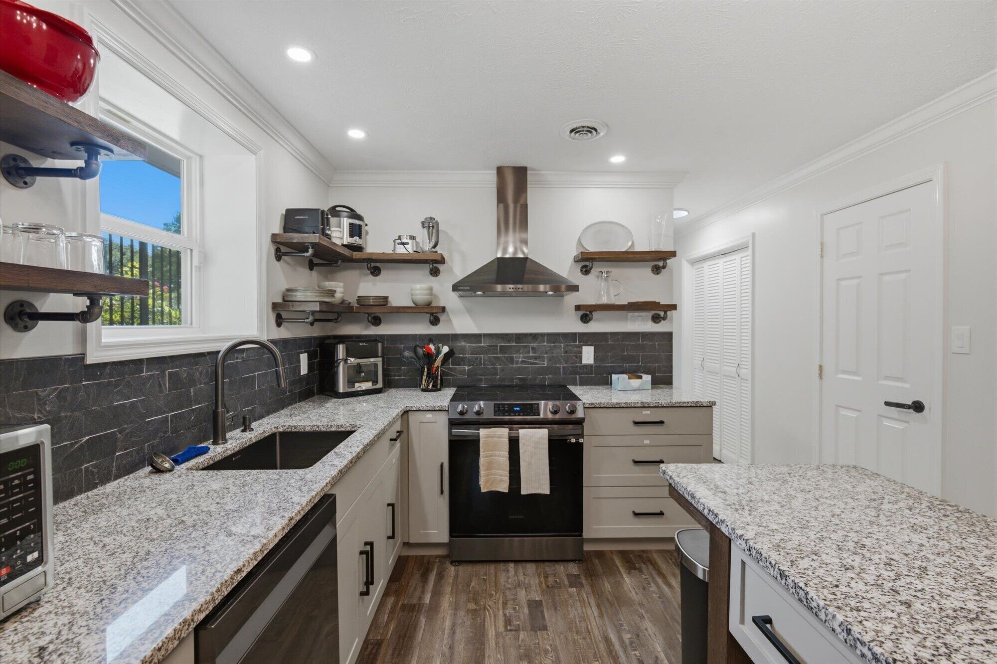 Bright modern kitchen with granite counters and stainless appliances