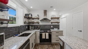 Bright modern kitchen with granite counters and stainless appliances