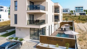Eine moderne Villa mit Schwimmbad, Balkonen und einer Zahnarztpraxis.