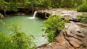 A natural landscape with a waterfall, rocky terrain, and lush greenery. - Full-Hookups, Free Laundry, Pet Park, Near Mt. Nebo and Lake Dardanelle- Adventure Awaits! (Dardanelle)
