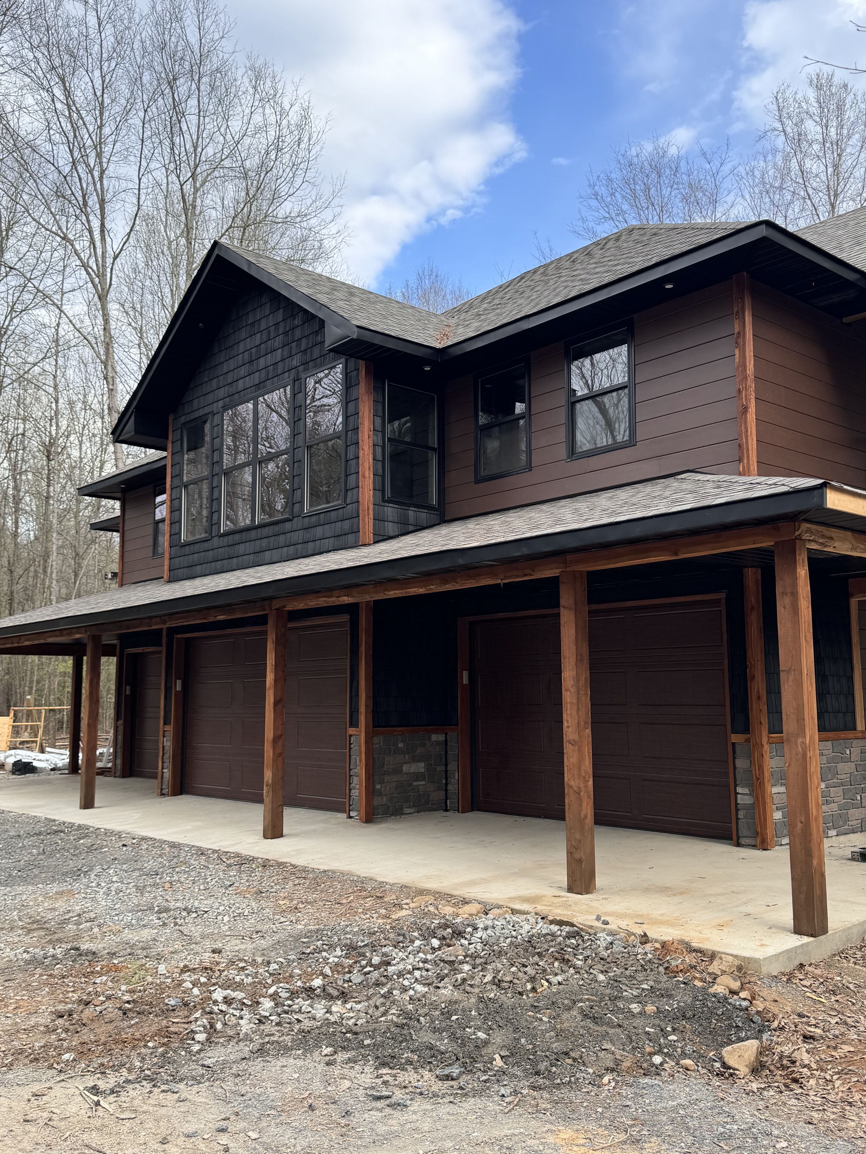 A two-story house with a covered front porch and two garage doors.
