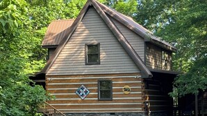 A log cabin with a stone foundation, a wooden staircase, and a gravel driveway. - A~Bears Den- Pet Friendly, Hot Tub, 2 King Suites, Minutes to GSMNP! (Townsend)