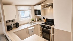 A modern kitchen with a built-in microwave, stove, and sink. - Bird Lake Pastures 2 Bedrooms 2 Baths  (Northampton)