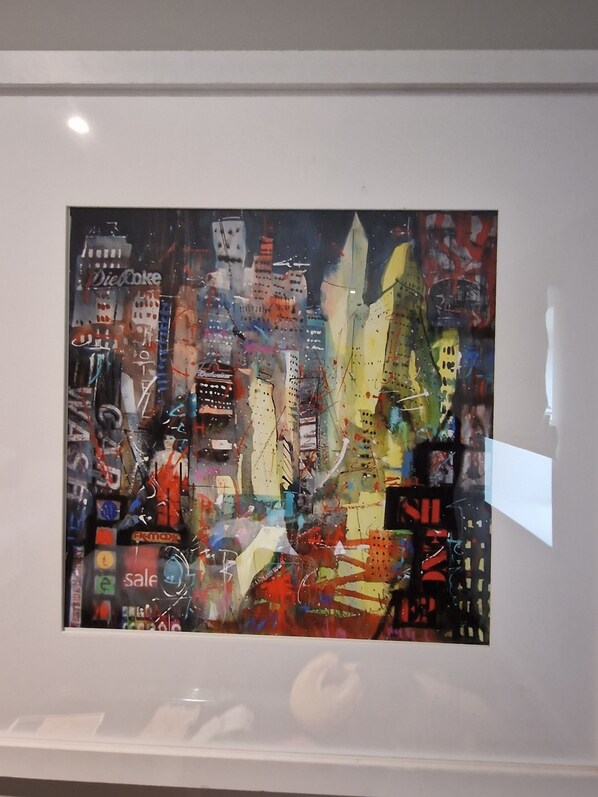 Una pintura abstracta enmarcada con elementos urbanos y texto.