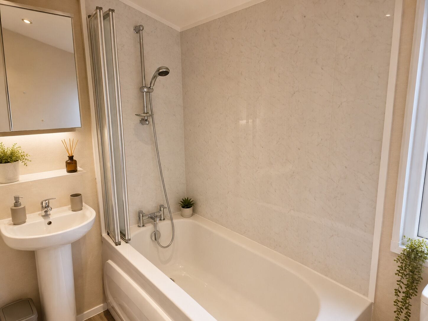 Een badkamer met een bad, douche, wastafel en spiegel.
