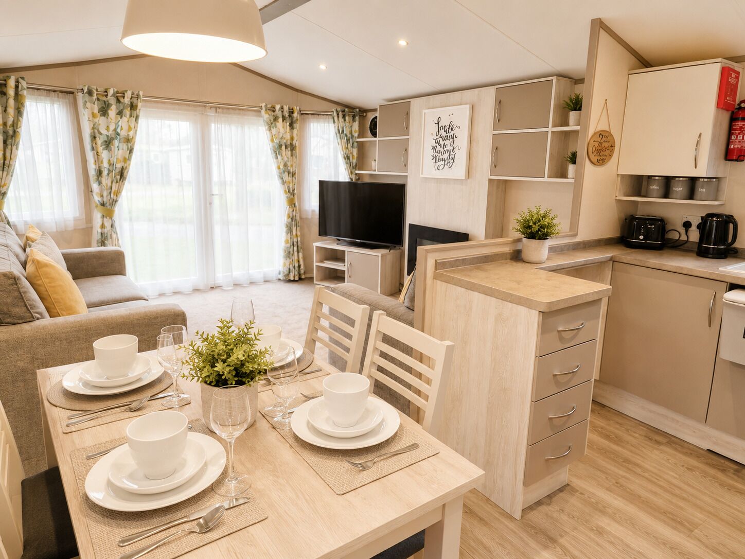 A modern apartment with a dining area, kitchen, living room, and a TV.