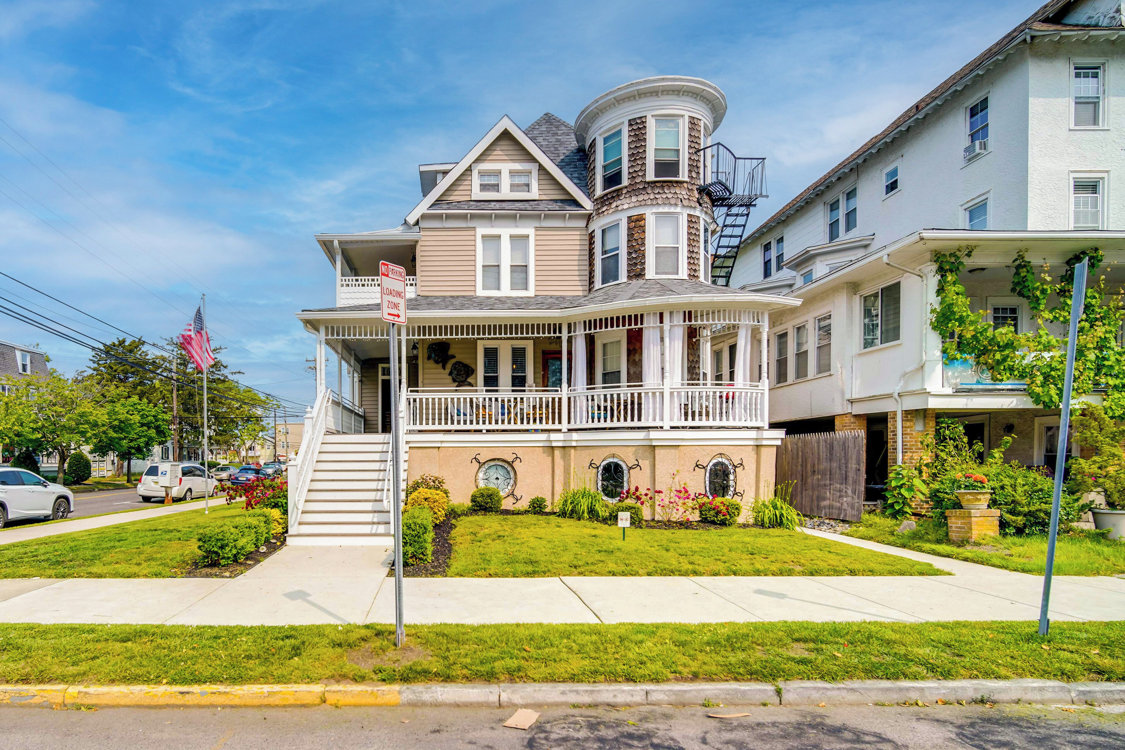 A Victorian-style house with a wrap-around porch, a bay window, and a turret.
