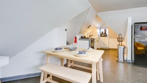 Una cocina moderna con una mesa de comedor y un banco, un refrigerador y un lavamanos.