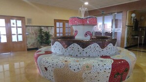 Una fuente de mosaicos circulares con un caño en un área de recepción.