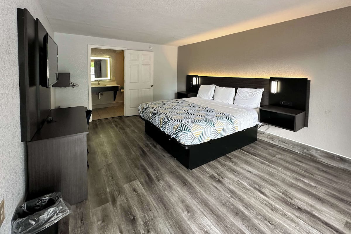 Een moderne slaapkamer met een groot bed, een ingebouwde televisie en een klein bureau.