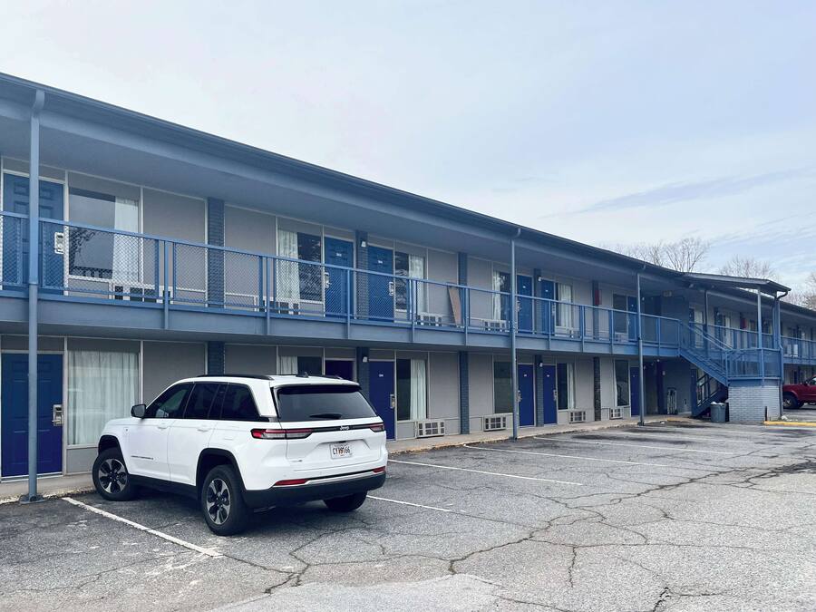 Ein Motel mit mehreren Etagen, Balkonen und einem Parkplatz.