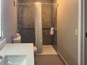 Tina con regadera, toallas, jabón, papel de baño 