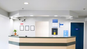 Un comptoir d’accueil avec une porte bleue portant l’inscription « PRIVÉ » sur le côté droit.