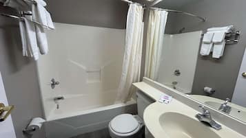Bañera con ducha, toallas, jabón, papel higiénico