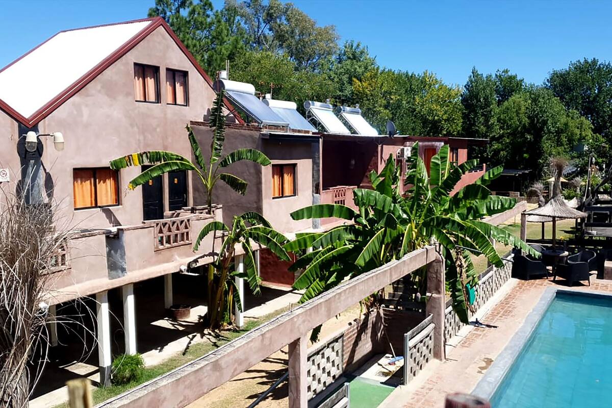 Un bâtiment à deux étages doté d’une piscine, entouré de verdure et d’arbres.