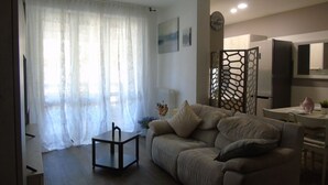 A living room with a sofa, a small table, and a decorative partition.