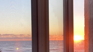 A window with a view of the sunset over the ocean. - Beachfront, clean, quiet, luxury condo on 3 rd fl amazing view! Walk to Tootsies (Panama City Beach)