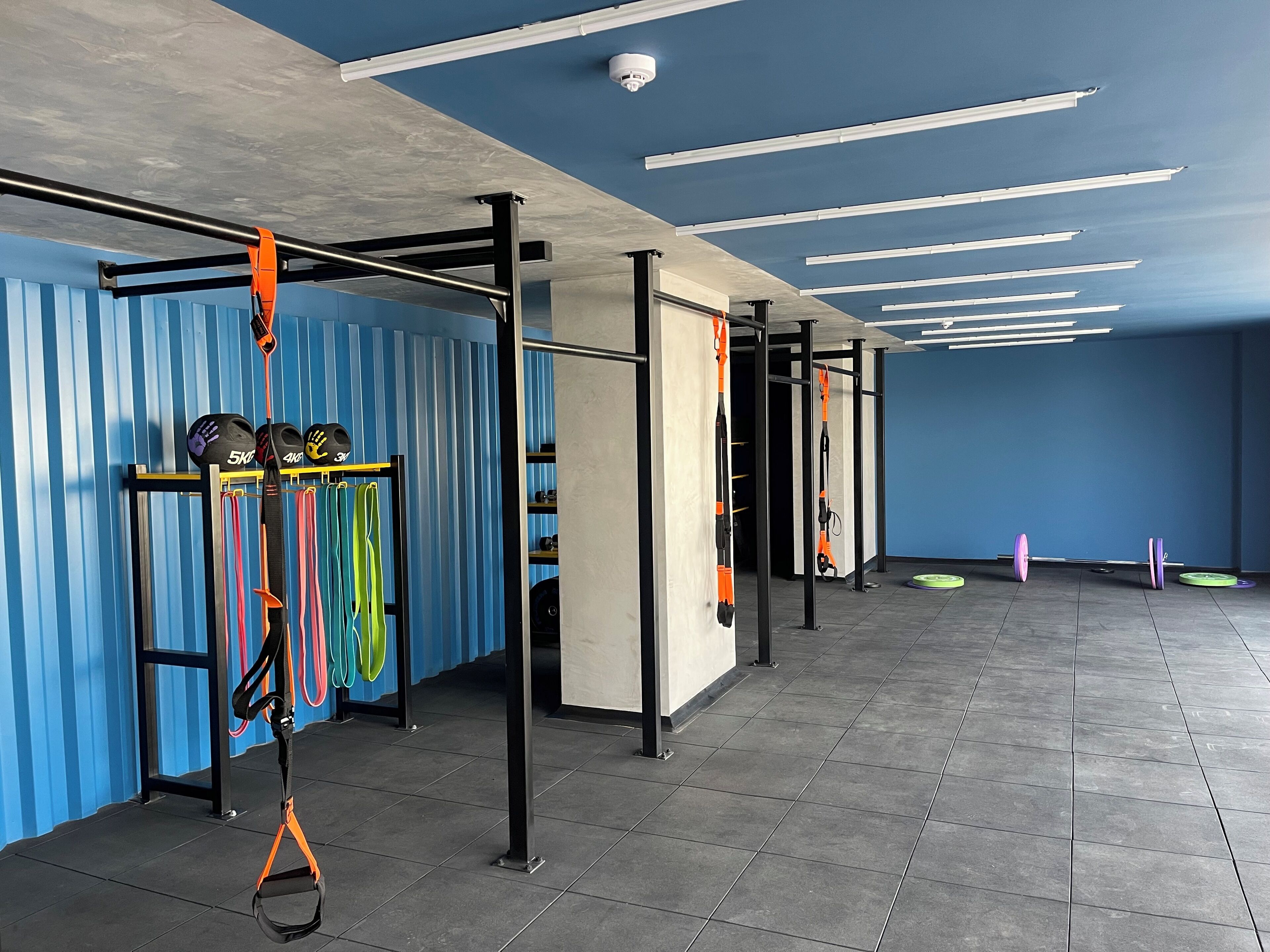 A gym with exercise equipment, including a pull-up bar and resistance bands.