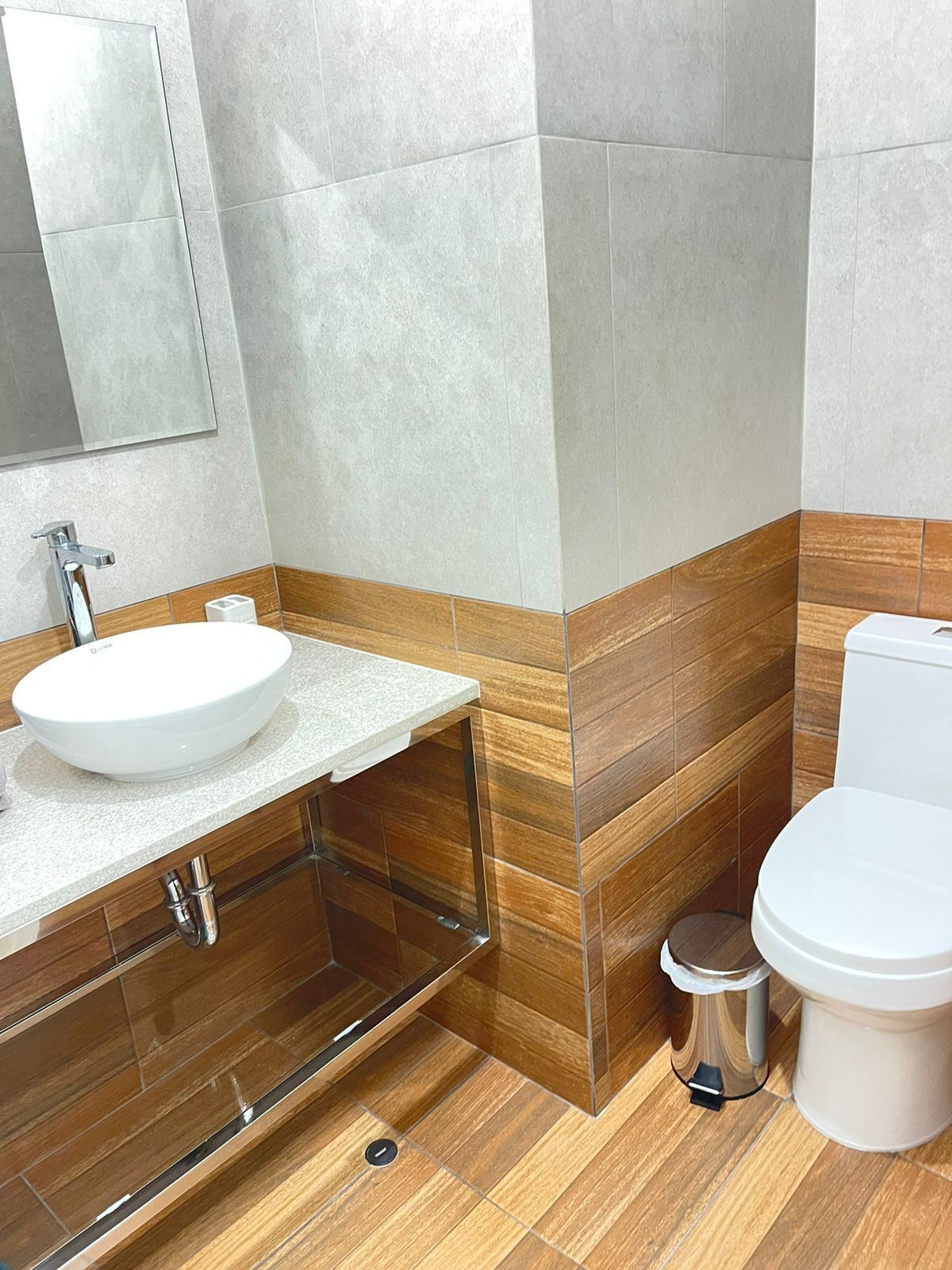 A bathroom with a white sink, mirror, and toilet.
