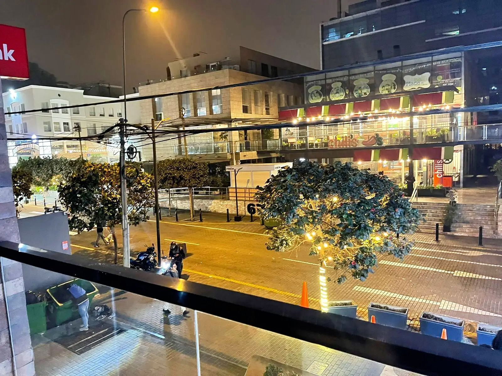 En gatubild med en restaurang som heter ”Chilis” och en byggnad med en skylt där det står ”Fach”.