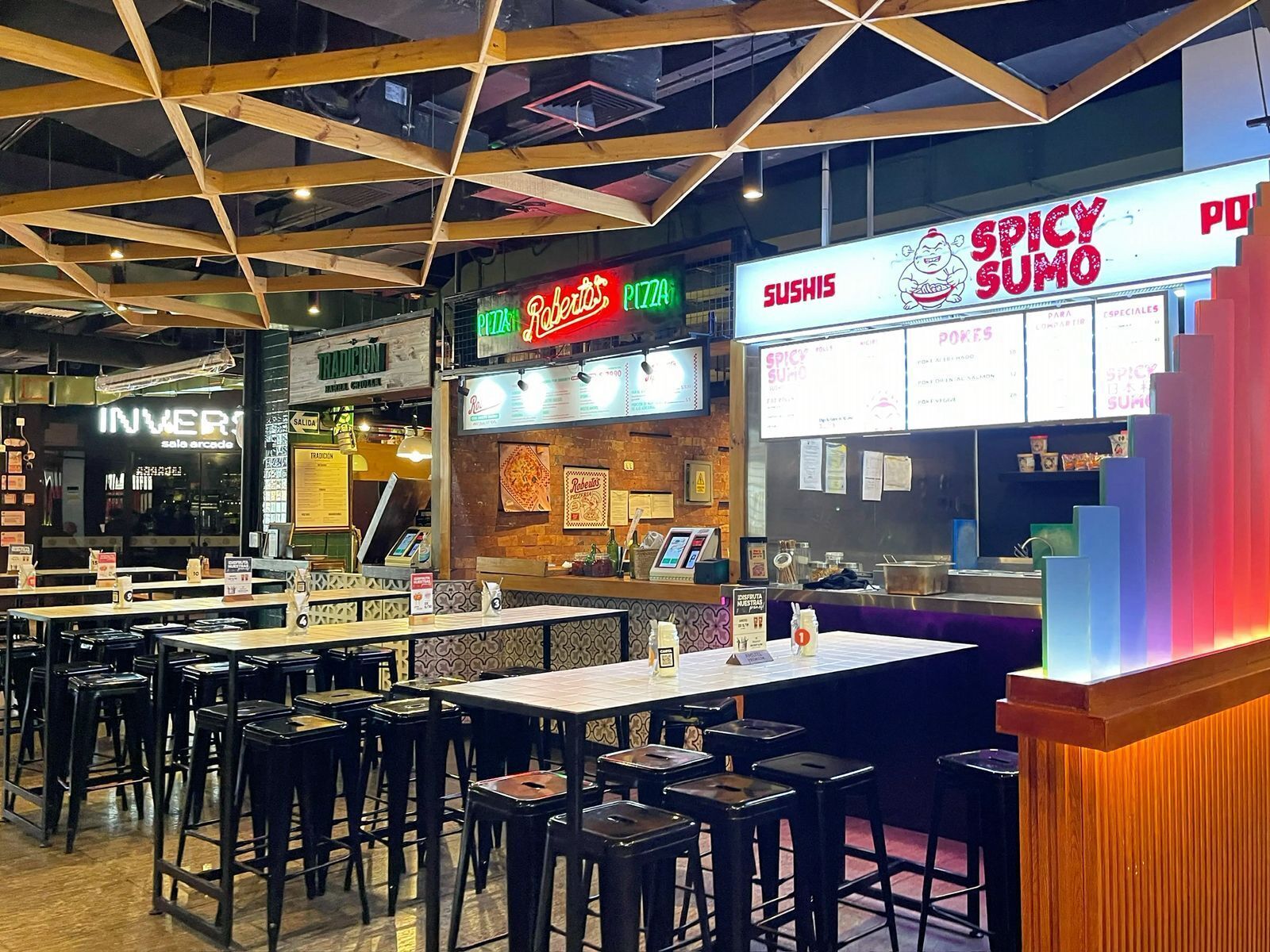 A restaurant with multiple seating areas, a pizza counter, and a sushi counter.