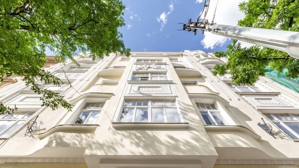 A multi-story building with a classical architectural style, featuring symmetrical windows and decorative moldings.