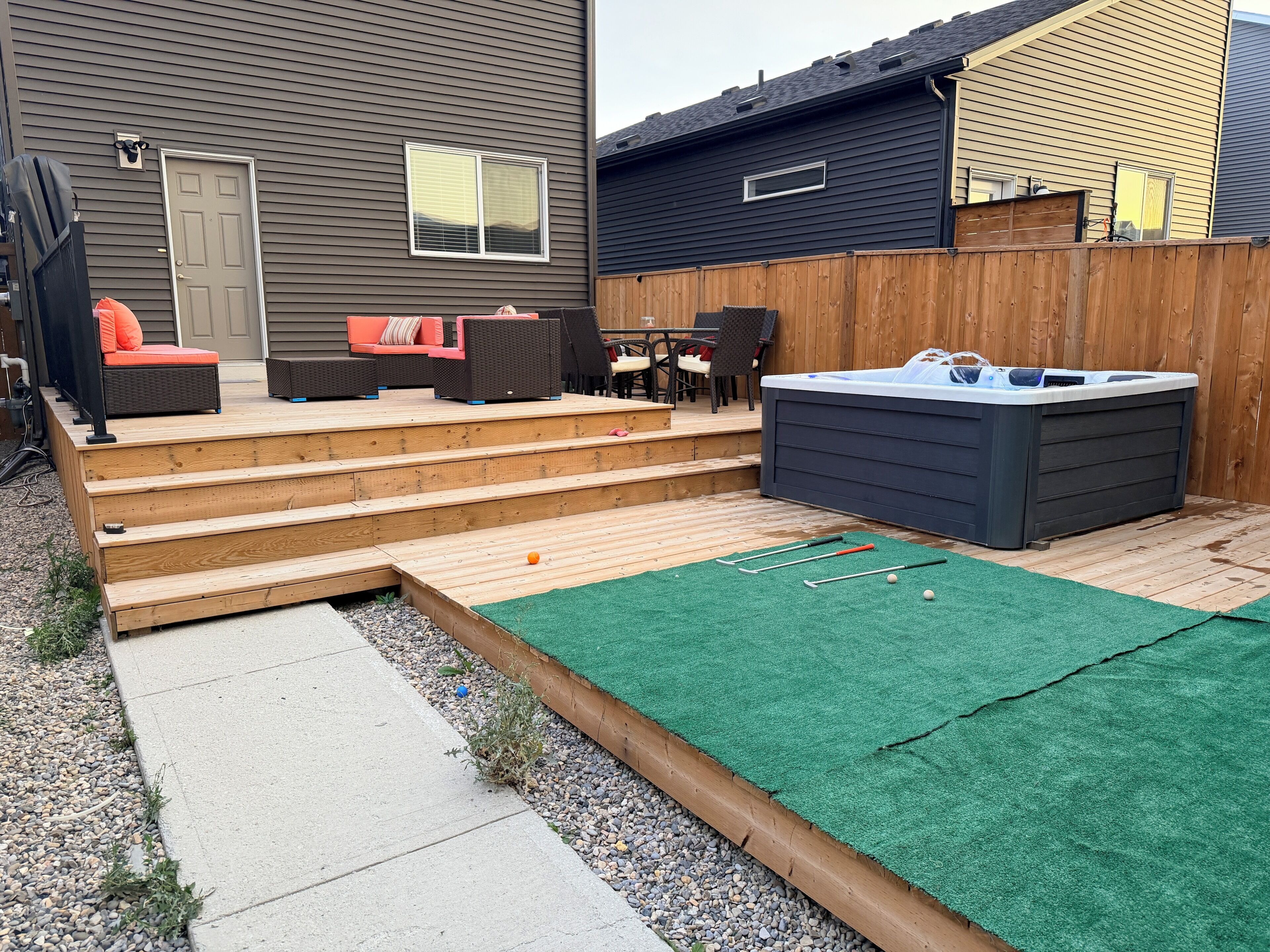 A backyard with a hot tub, outdoor seating, and a small pool.