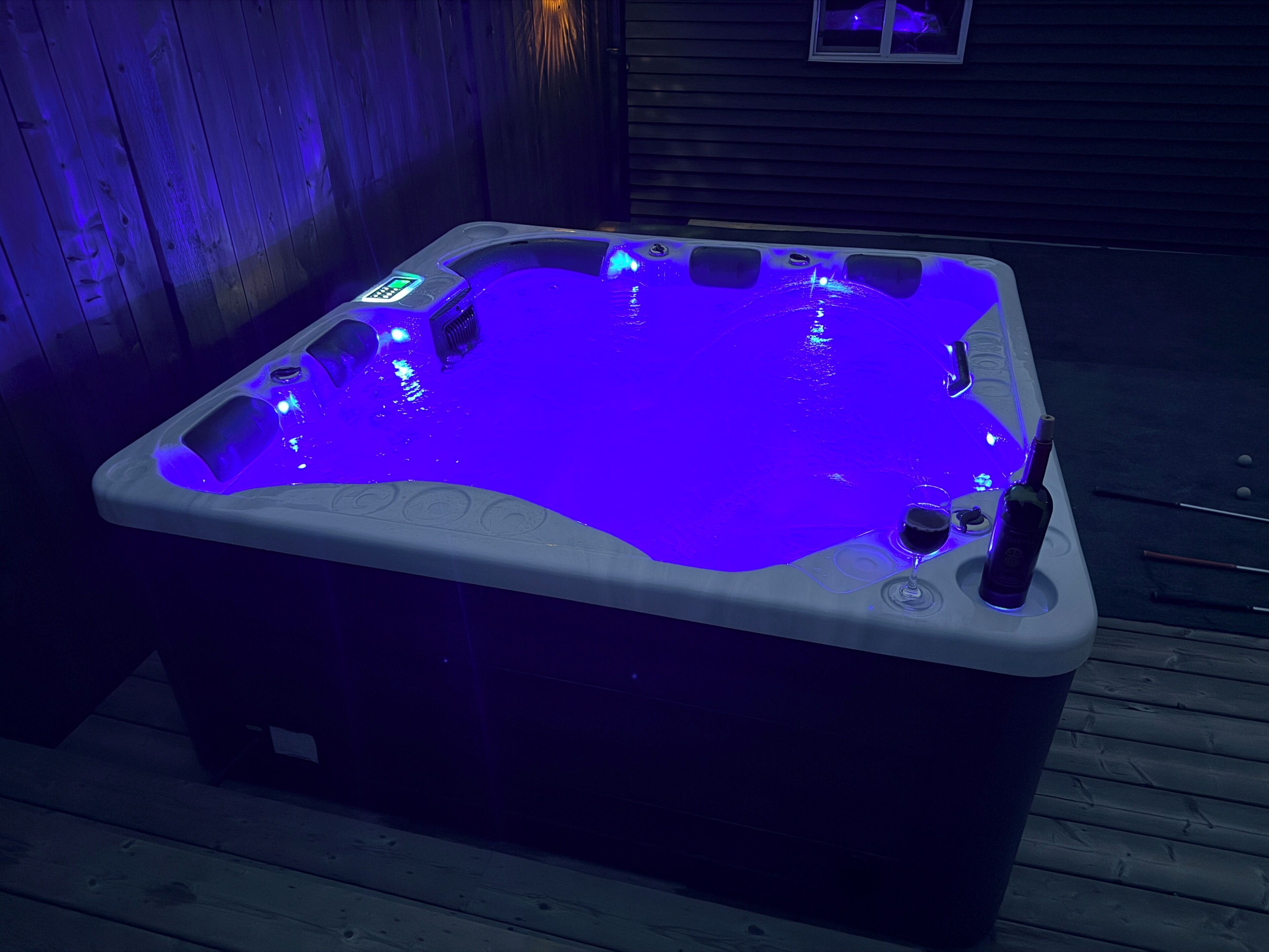 A hot tub with a digital control panel and a glass on the side.