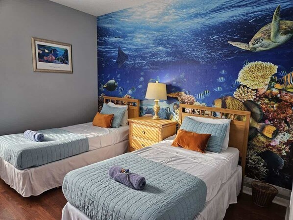 A room with two beds, a nightstand, and a mural of an underwater scene. - Discovering Nemo and Dori Paradise! 2 min to Posner Park (Davenport)