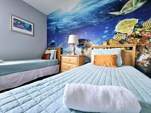 A bedroom with two beds, a nightstand, a lamp, and an underwater mural on the wall. - Discovering Nemo and Dori Paradise! 2 min to Posner Park (Davenport)