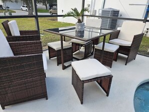 A patio area with wicker furniture, a glass table, and a pool. - Discovering Nemo and Dori Paradise! 2 min to Posner Park (Davenport)