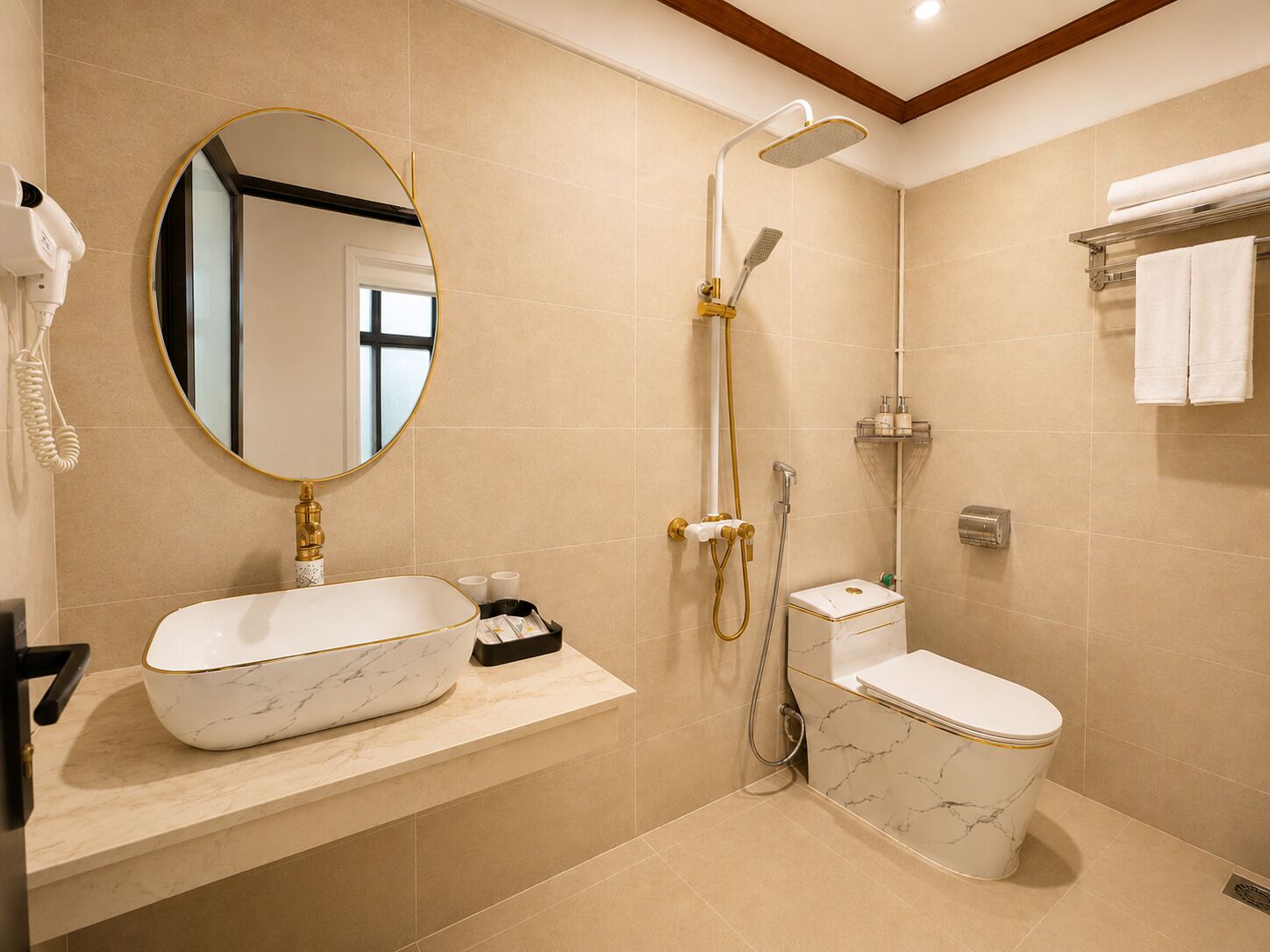A bathroom with a marble sink, a toilet, a shower with a handheld showerhead, and a towel rack.