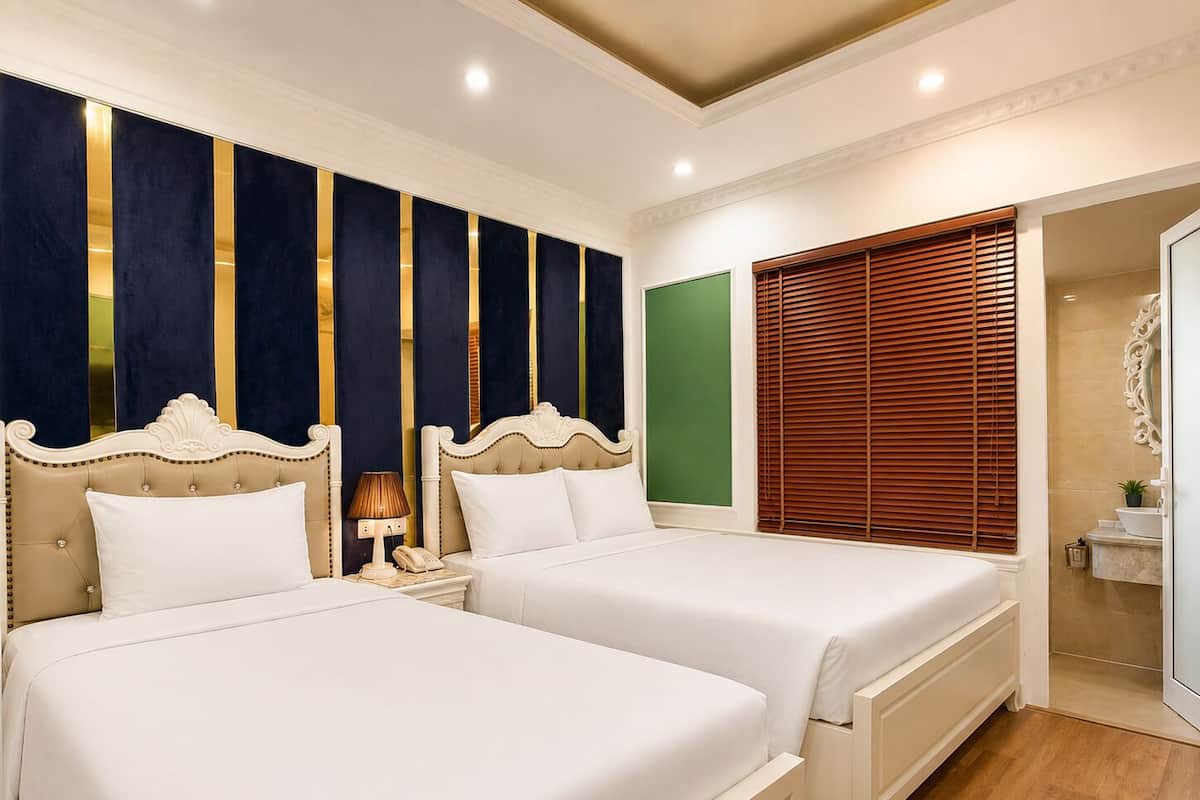 A double bed room with a nightstand, a lamp, and a green accent wall.