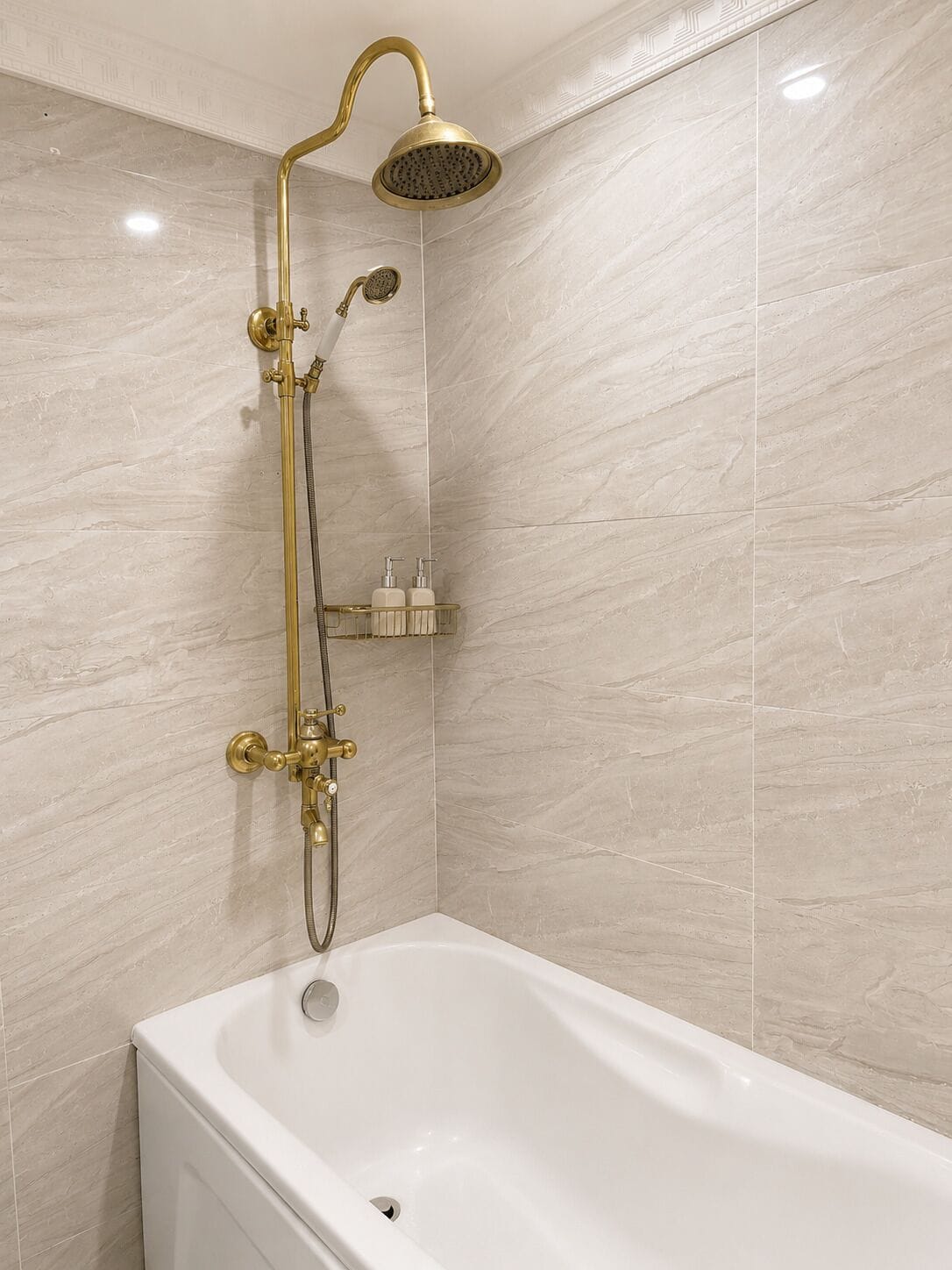 Ein Badezimmer mit einer weißen Badewanne, einem goldfarbenen Duschkopf und einer Handbrause.