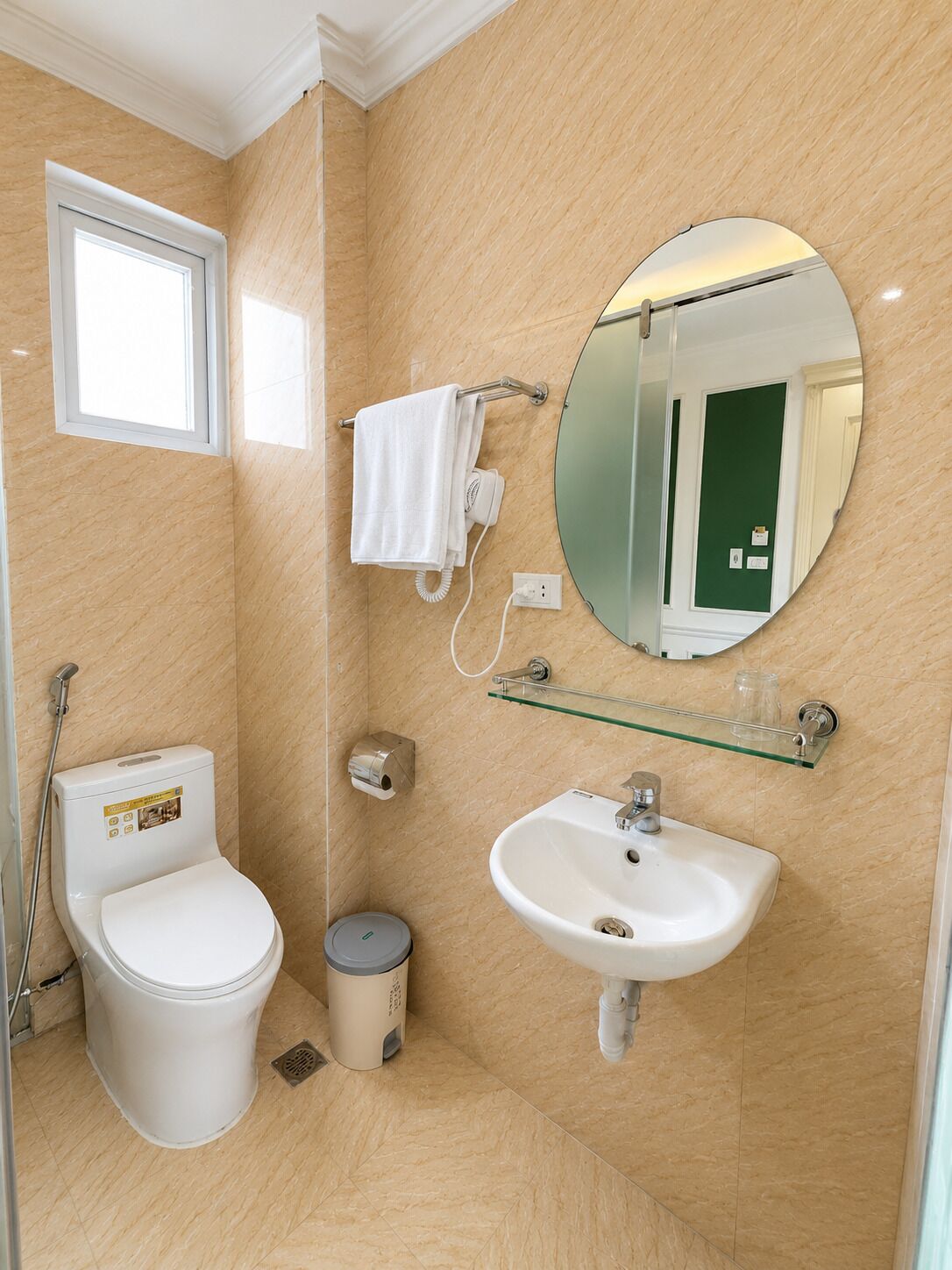A bathroom with a toilet, sink, mirror, towel rack, and a window.