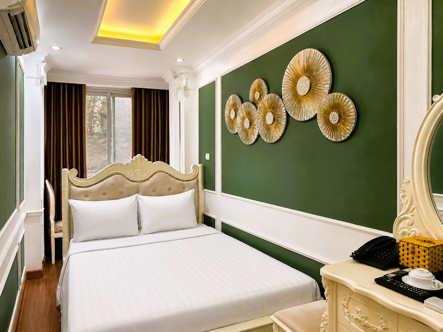 A hotel room with a large bed, a dresser, a mirror, and decorative wall art.