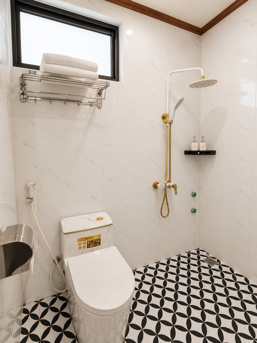 Et badeværelse med toilet, bruser, et vindue og et mønstret gulv.