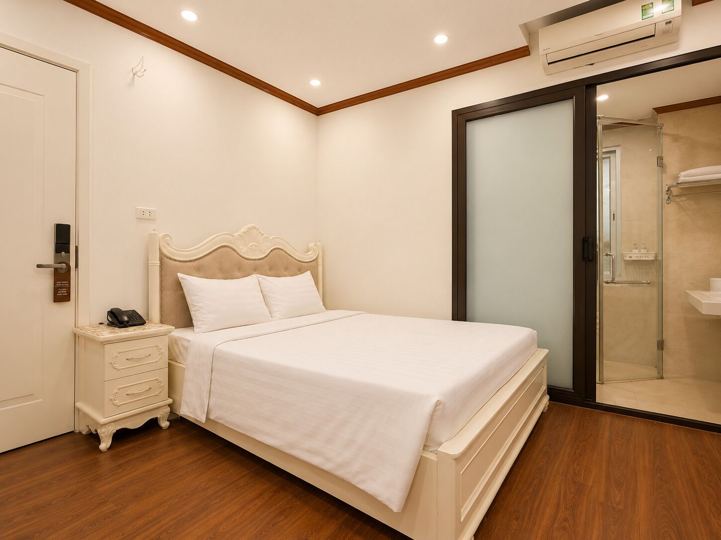 A bedroom with a bed, bedside table, and an air conditioning unit.