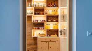 Ein Holzschrank mit mehreren Regalen, gefüllt mit verschiedenen Gegenständen.
