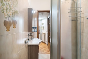 Une salle de bain équipée d’un lavabo, d’un miroir et d’un porte-serviettes.