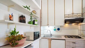 A compact kitchen with white cabinets, a microwave, a sink, and a stove. - Apartment 'Mare, Sole, Eucalipto' with Sea View, Private Terrace and Air Conditioning (Piani-Ciapin)