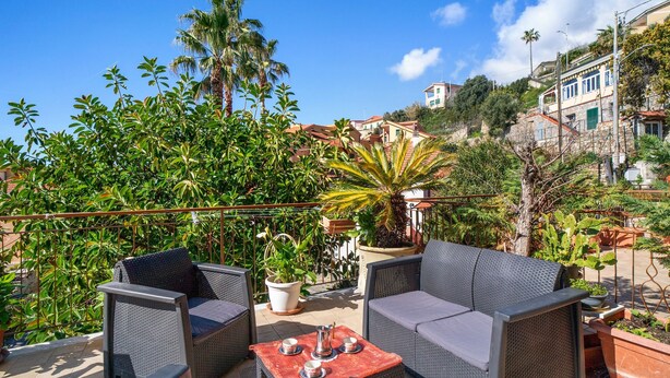 An outdoor patio with wicker furniture, a table with cups and a pitcher, and potted plants. - Apartment 'Mare, Sole, Eucalipto' with Sea View, Private Terrace and Air Conditioning (Piani-Ciapin)