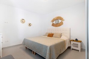 A bedroom with a bed, a nightstand, and a wall-mounted eye decoration.