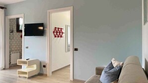 Ein modernes Wohnzimmer mit einem beigefarbenen Sofa, einem an der Wand montierten Fernseher und einer Holzunterhaltungsecke.