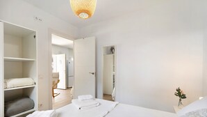 Een hotelkamer met een bed, een kledingkast, een spiegel en een kleine tafel met een vaas.